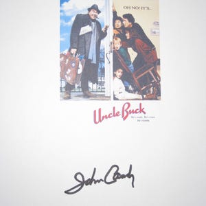 May include: A movie poster for "Uncle Buck" featuring John Candy. The poster shows Candy as the main character, holding a suitcase and smoking a cigar. The title and Candy's signature are also visible.