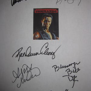 May include: A white paper with multiple black signatures and a small image of Arnold Schwarzenegger from the movie "Commando". The image has the movie title in red and white text.