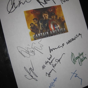 以下が含まれることがあります： 白い紙に、映画「キャプテン・アメリカ」のポスターと、黒、青、緑のインクで書かれた複数のサインが描かれています。ポスターにはキャプテン・アメリカと他のキャラクターが描かれています。「CAPTAIN AMERICA THE FIRST AVENGER」の文字が見えます。