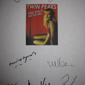 May include: A white sheet of paper with black and blue signatures. The signatures include "Ray Wise", "David Lynch", "M Weller", "Mark Frost", and "Sherilyn Fenn". The paper also has a small, red, white, and black poster for the show "Twin Peaks" with the text "Fire Walk With Me".