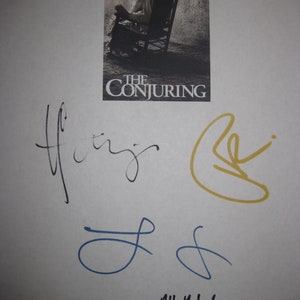 May include: A white background with a small movie poster for "The Conjuring" featuring a woman and child in a rocking chair. Several signatures in black, blue, and yellow ink are present, along with the handwritten phrase "All the best, RaJ" in black ink.