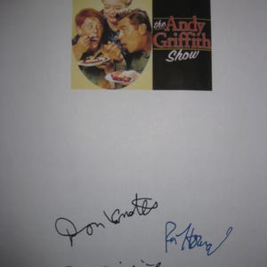 May include: A print featuring the Andy Griffith Show logo and a scene of three people eating pie. The print is signed by Don Knotts, Ron Howard, and Andy Griffith. The signatures are in black and blue ink.