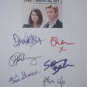 May include: A white sheet of paper with the title "The Mentalist" at the top. The image features a photo of two actors from the show. The paper is signed by the actors, including Simon Baker, Robin Tunney, and others.