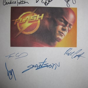 May include: A printed image of The Flash with the show's logo and a portrait of the character. The image is signed by several people in blue ink. The background is white.