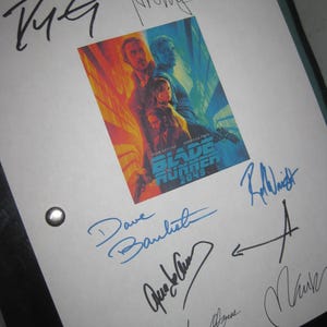 May include: A white sheet with multiple signatures in black and blue ink. A movie poster for "Blade Runner 2049" is in the center. The poster features Ryan Gosling and Harrison Ford.