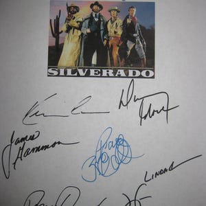 May include: A promotional image for the film "Silverado" featuring a group of actors in Western attire. The image is surrounded by multiple signatures in black and blue ink. The film's title is displayed in white block letters.