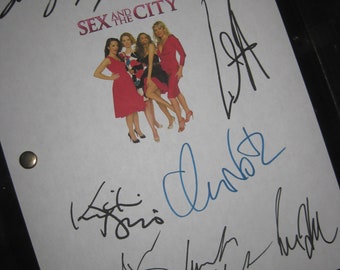 May include: A white sheet of paper with black signatures from the cast of the TV show "Sex and the City". The signatures include Sarah Jessica Parker, Kristin Davis, Cynthia Nixon, Kim Cattrall, and the show's creator, Darren Star.