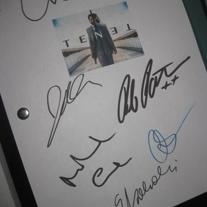 May include: A white sheet of paper with black ink signatures from the cast and crew of the movie "Tenet". The signatures include "Christopher Nolan", "Robert Pattinson", "John David Washington", and "Elizabeth Debicki". The movie poster for "Tenet" is in the upper right corner of the page.