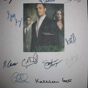 Puede incluir: Una hoja de papel blanca con varias firmas en tinta negra y azul. Las firmas son del elenco del programa de televisión "Arrow". Las firmas incluyen Stephen Amell, Katie Cassidy, Colin Donnell, Susanna Thompson, Paul Blackthorne, David Ramsey, Willa Holland y John Barrowman. El texto "This disaster has his family name all over it." es visible en la imagen.