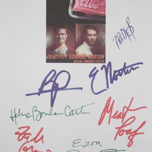 May include: A white print featuring the movie "Fight Club" with images of Brad Pitt and Edward Norton. The print includes the film's title and the actors' names, along with several signatures in various colors.