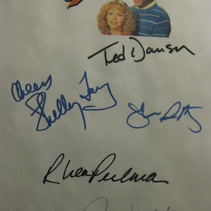 Könnte beinhalten: Ein weißes Papier mit dem "Cheers"-Logo und Bildern der Schauspieler Ted Danson und Shelley Long. Das Papier ist mit blauer und schwarzer Tinte von den Darstellern signiert, darunter Ted Danson, Shelley Long, Rhea Perlman und George Wendt.