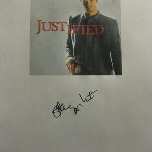 Könnte beinhalten: Werbebild für die Fernsehserie "Justified" mit einem Mann in Hut und Anzug. Der Titel der Show ist in roter Schrift. Das Bild ist mit schwarzer Tinte signiert.
