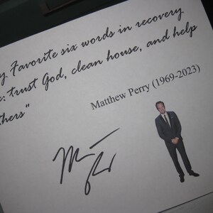 May include: A white card with the quote "My Favorite six words in recovery are: trust God, clean house, and help others." The card includes a photo of Matthew Perry, his signature, and the years 1969-2023.