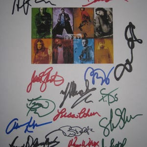 May include: A white sheet of paper featuring a collage of images from the musical "Rent" with multiple signatures in various colors. The collage includes images of the cast and the title "Rent" with the date "11.23.05".