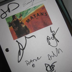 May include: A white sheet with a "Mayans M.C." poster and multiple signatures in black ink. The poster features a man on a motorcycle. The signatures are in various styles and sizes.
