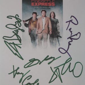 May include: A movie poster for "Pineapple Express" featuring Seth Rogen and James Franco. The poster has the movie title in red and white text. The poster is signed in green and purple marker.