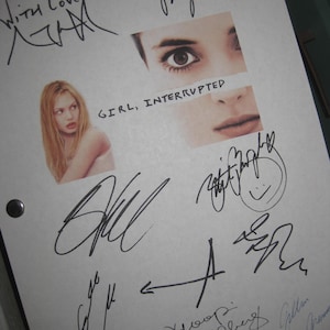 May include: A white sheet with multiple signatures in black ink, and a few in red ink. The sheet has two images of a woman's face and the text "GIRL, INTERRUPTED". The top left corner has the words "With love".
