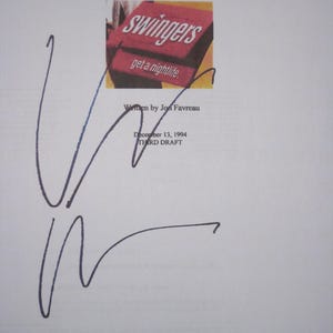 May include: A white sheet of paper with text and a signature. The text includes "A Doug Liman Film" and "swingers get a nightlife." The signature is in blue ink. Additional text reads "Written by Jon Favreau" and "December 13, 1994 THIRD DRAFT."
