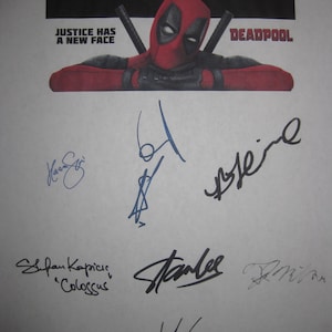 Op de afbeelding: Een print met het Deadpool-personage in een rood en zwart kostuum, met de tekst "JUSTICE HAS A NEW FACE" en "DEADPOOL". De print is bedekt met handtekeningen, waaronder "Stan Lee" en "Colossus".