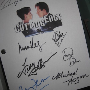 May include: A white script page featuring the movie title The Cutting Edge with a graphic of two figures, surrounded by multiple black and blue ink signatures. The page includes two metal grommets on the left side and various handwritten autographs.