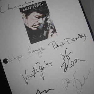 May include: A white sheet of paper with multiple signatures in black ink. The image includes a small book cover with the title "Death Wish" and a portrait of a man holding a gun. The signatures are from various individuals.