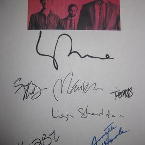 May include: A promotional image for "Halt and Catch Fire" featuring the show's title and cast. The image is signed by several individuals. The title is in red and white, and the signatures are in black and blue ink.