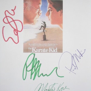 May include: A signed poster for "The Karate Kid" movie. The poster features two faces and a figure in a karate stance. The text reads "He taught him the secret to Karate lies in the mind and heart. Not in the hands." and "The Karate Kid".