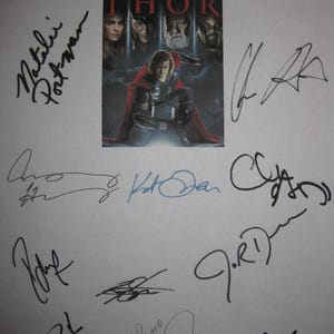 Può includere: Un foglio bianco con un poster del film "Thor" al centro, circondato da diverse firme in inchiostro nero e blu. Il poster presenta Chris Hemsworth come Thor. Le firme includono Natalie Portman e Stan Lee.