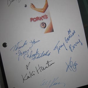 Może przedstawiać: Biała kartka papieru z wieloma podpisami niebieskim tuszem. Słowo "Porky's" jest widoczne na małym obrazku. Podpisy wydają się być autografami, prawdopodobnie z filmu lub programu.