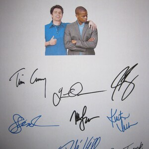 May include: A white poster featuring the word "psych" in blue, with two men in the center. The poster includes multiple signatures in blue and black ink. One man is wearing a blue shirt and giving a thumbs up, while the other is in a gray blazer.
