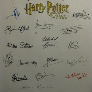 Può includere: Una pagina con diverse firme, con il titolo "Harry Potter and the Goblet of Fire" in lettere dorate. Le firme sono in inchiostro nero, con una in rosso. Le firme variano per stile e dimensione.