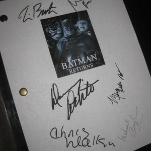 Może przedstawiać: Czarno-białe zdjęcie obsady filmu Batman Returns, w tym Michelle Pfeiffer, Michaela Keatona i Danny'ego DeVito, z ich autografami na białej kartce. Tytuł filmu "Batman Returns" jest wydrukowany pod zdjęciem.