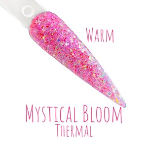 May include: A nail swatch with a pink glitter design. The text "WARM" is written in pink script. The text "MYSTICAL BLOOM THERMAL" is written in pink script below the nail swatch.
