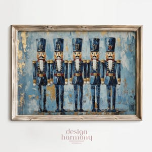 May include: A framed print depicting five toy soldier nutcrackers. They wear blue uniforms with gold trim, black boots, and tall hats. The background is textured blue with gold leaf accents. The frame is light wood. The print is a festive decoration.