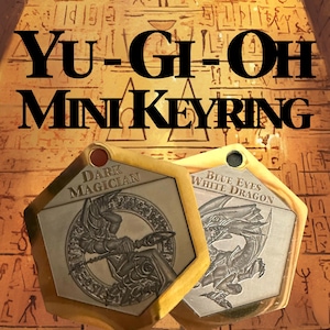 Pode incluir: Dois mini porta-chaves hexagonais Yu-Gi-Oh. Um apresenta o Mago Negro, o outro o Dragão Branco de Olhos Azuis. Os porta-chaves têm uma borda dourada e estão sobre um fundo com hieróglifos. O texto "Yu-Gi-Oh Mini Keyring" está no topo.