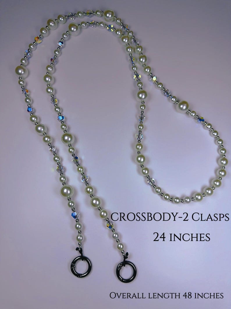 May include: A white pearl and crystal beaded chain with two black metal clasps. The chain is 48 inches long and has two 24-inch sections. CROSSBODY-2 CLASPS 24 INCHES OVERALL LENGTH 48 INCHES