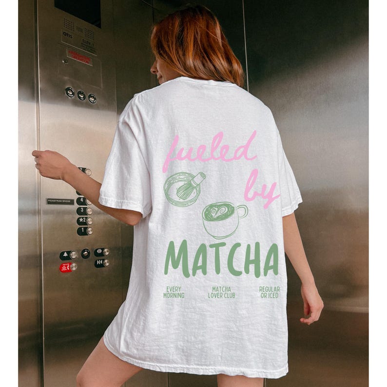 May include: White t-shirt with a green and pink graphic that says "fueled by matcha" with illustrations of a whisk and a cup of matcha. The text below the graphic says "Every Morning, Matcha Lover Club, Regular or Iced."