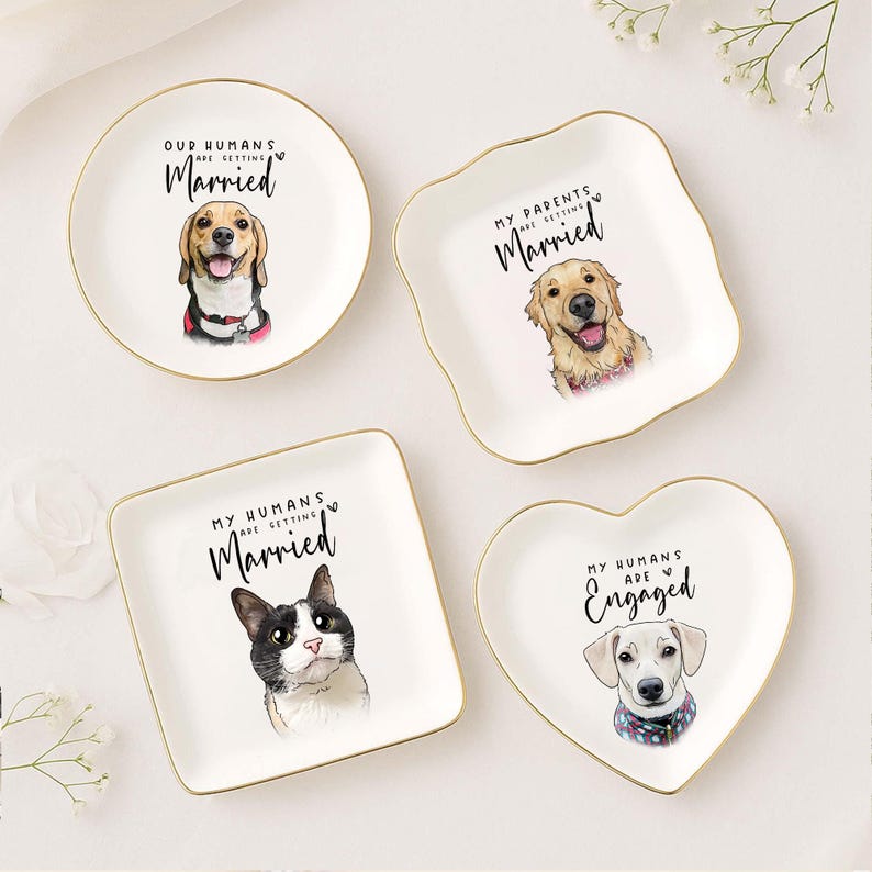 May include: Four white ceramic ring dishes with gold rims. Each dish features a different pet portrait and text: "Our Humans are Getting Married," "My Parents are Getting Married," "My Humans are Getting Married," and "My Humans are Engaged."