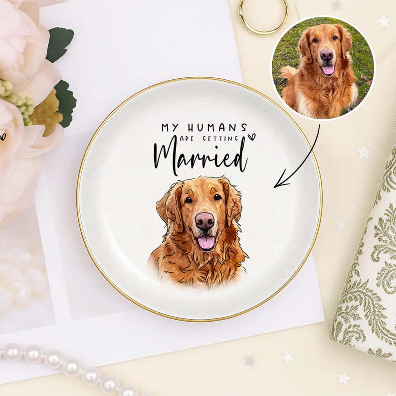 May include: A white ceramic ring dish with a gold rim features a watercolor illustration of a golden retriever and the text "MY HUMANS ARE GETTING Married". A small circular photo of the dog is also included.