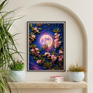 May include: A rectangular wall art print featuring a textured dark blue night sky with a large, glowing full moon and scattered stars. Branches with light pink cherry blossoms extend across the composition, creating a contrast between the floral elements and the deep, dark background.