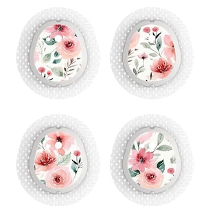 Op de afbeelding: Vier witte ronde pleisters met een bloemenpatroon. Het patroon heeft roze en rode aquarelbloemen en groene bladeren op een witte achtergrond.