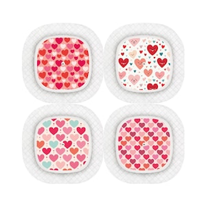 May include: Four white adhesive bandages with a square shape and a white border. Each bandage has a different pattern of red, pink, and blue hearts.