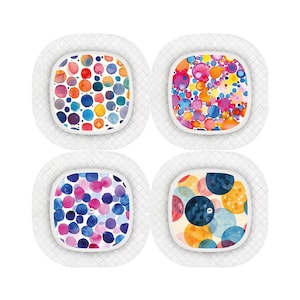 May include: Four white square plates with colorful watercolor designs of circles. Each plate has a different pattern of circles in shades of blue, pink, yellow, orange, and green.