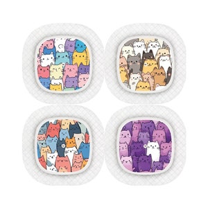 Op de afbeelding: Vier vierkante pleisters met een kleurrijk cartoon-kattenpatroon. Elke pleister heeft een ander kleurenschema: roze, paars, blauw en geel.