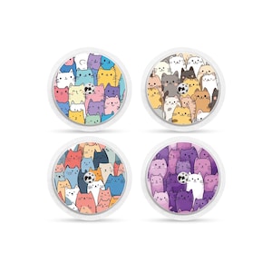 Könnte beinhalten: Vier runde Aufkleber mit weißem Hintergrund und einem Design aus bunten Comic-Katzen. Die Katzen sind alle in verschiedenen Farben und haben verschiedene Gesichtsausdrücke.