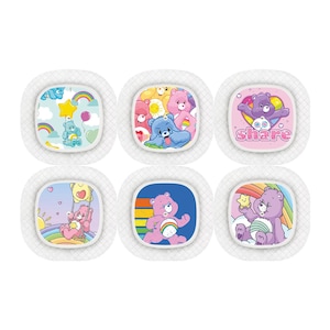 Puede incluir: Seis vendas redondas de colores con personajes de los Osos Amorosos. Cada venda presenta un Oso Amoroso diferente con un arcoíris y un mensaje. Los mensajes son "Compartir", "Cuidar", "Amor", "Amigo", "Diversión" y "Creer".