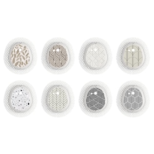 Puede incluir: Ocho parches adhesivos con diferentes patrones para un dispositivo médico. Los parches presentan diseños geométricos en negro, blanco, marrón y gris.