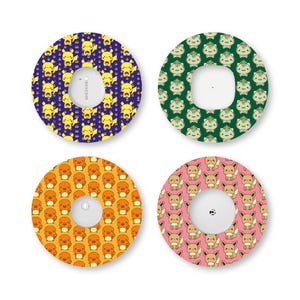May include: Four circular adhesive patches for medical sensors, each featuring a repeating pattern of a different cartoon character. The designs include yellow Pikachu on purple, green Bulbasaur on dark green, orange Charmander, and brown Eevee on pink.