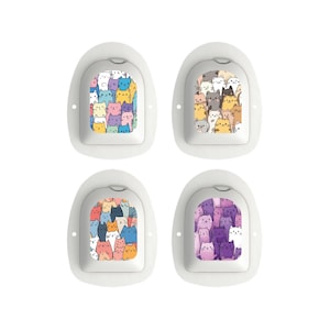 Puede incluir: Cuatro parches médicos blancos con bordes redondeados, cada uno con un patrón de gato colorido diferente. Los diseños de gatos incluyen varios colores como azul, amarillo, rosa y morado. Los parches están dispuestos en una cuadrícula de 2x2.