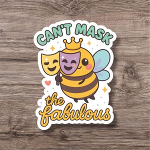 Puede incluir: Una pegatina con una abeja de dibujos animados que lleva una corona y sostiene dos máscaras de teatro. El texto "Can't Mask the Fabulous" está escrito encima y debajo de la abeja en una fuente juguetona. La abeja es amarilla y negra con alas azules.